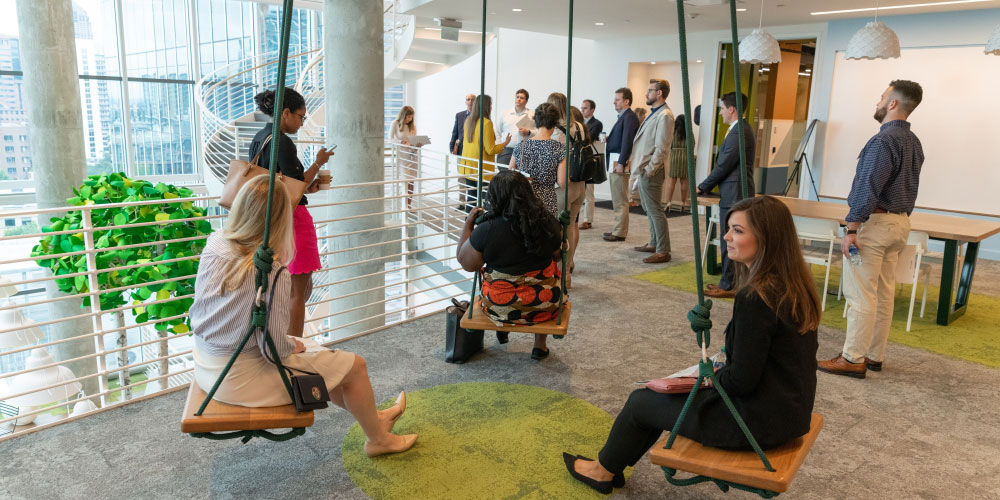 students gathered on swings in the Coda building